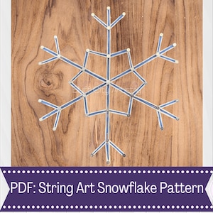 May include: A blue and white string art snowflake pattern on a wooden background. The pattern is made with nails and string. The text "PDF: String Art Snowflake Pattern" is at the bottom of the image.