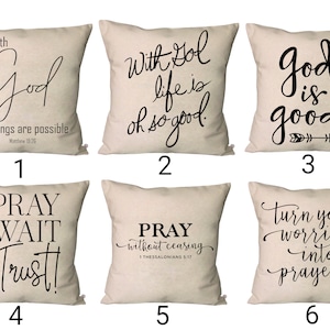 Puede incluir: Seis fundas de cojín beige con texto negro. Los cojines presentan citas inspiradoras sobre la fe y la oración. Las citas incluyen "Con Dios la vida es tan buena", "Dios es bueno", "Ora, espera, confía", "Ora sin cesar 1 Tesalonicenses 5:17", y "Convierte tus preocupaciones en oraciones".