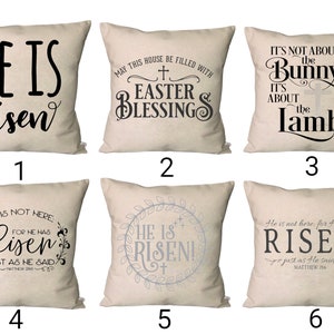 May include: Six different throw pillow designs with Easter-themed messages. The pillows are all beige with black and gray lettering. The messages include "He is risen", "May this house be filled with Easter blessings", "It's not about the bunny, it's about the lamb", "He is not here, for he has risen, just as he said", "He is risen!" and "He is not here, for he has risen, just as he said".
