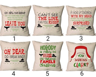 Puede incluir: Seis almohadas beige con diferentes citas e imágenes con temática de Vacaciones de Navidad. Las almohadas presentan texto e imágenes rojas y verdes. Las citas incluyen "¿Puedo rellenar tu ponche de huevo?", "No veo la línea. ¿Tú sí, Russ?", "Si me despertara mañana con la cabeza cosida a la alfombra, no estaría más sorprendido de lo que estoy ahora", "Ay, Dios mío. ¿Me tiré un pedo?", "Nadie se va de esta divertida y tradicional Navidad familiar", y "¿En serio, Clark?".