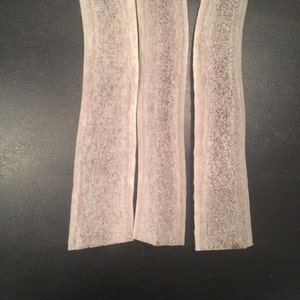May include: Three white deer antler chews, each about 6 inches long, with a slightly curved shape and a rough, textured surface.