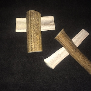 May include: Three antler dog chews, two are flat and one is a long, round bone.