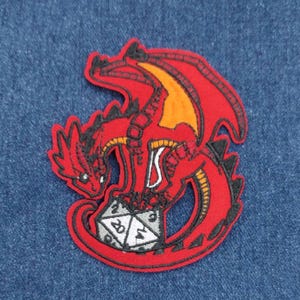 May include: Red embroidered patch of a dragon curled around a 20-sided die.