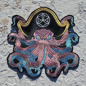 May include: Embroidered patch of a purple octopus wearing a black pirate hat with a gold trim and a white geometric design. The octopus has blue tentacles.