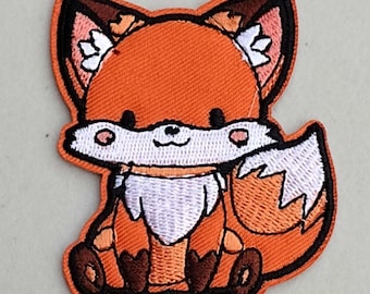May include: A cute orange and white embroidered fox patch with a smiling face. The fox is sitting with its tail curled around its body.