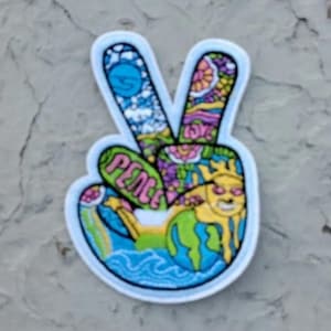 May include: A colorful peace sign patch with a peace symbol and a world globe design. The patch is embroidered with a variety of colors, including pink, blue, green, yellow, and orange.