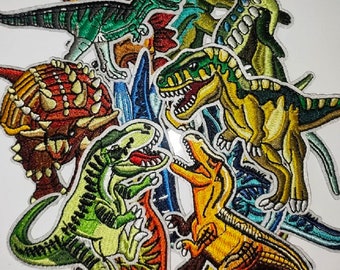 May include: A collection of colorful embroidered iron-on patches featuring various dinosaurs, including a green Tyrannosaurus Rex, a red Triceratops, and a yellow Stegosaurus.