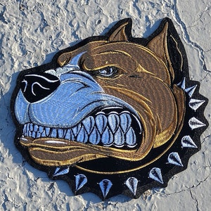 May include: Embroidered patch of a brown and white pit bull dog with a spiked collar. The dog has an aggressive expression with bared teeth. The patch is on a white background.