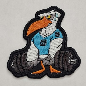 May include: An embroidered patch of a cartoon seagull wearing a blue shirt and lifting weights. The seagull has a determined expression and is sweating. The patch is black with white, orange, and gray accents.