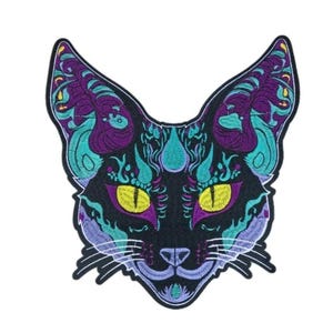 May include: Embroidered patch featuring a stylized black cat face with intricate designs in teal, purple, and yellow. The cat has large, yellow eyes and detailed patterns on its ears and forehead, creating a striking visual.