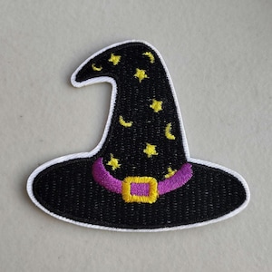May include: Embroidered patch of a black witch hat with a white border. The hat features yellow stars and crescent moons, a purple band, and a gold buckle. This patch is perfect for Halloween-themed crafts and apparel.