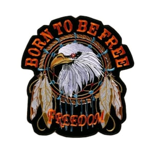 May include: An embroidered patch featuring a white eagle head centered within a circular dreamcatcher design. The text BORN TO BE FREE is arched above in orange, with FREEDOM written below. Two feathers hang from the sides on a black background.