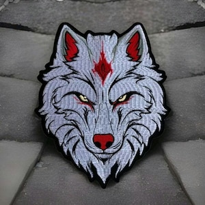May include: White wolf head embroidered patch with red accents. The wolf has a fierce expression with sharp teeth and a red nose.