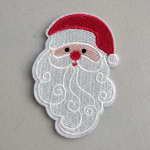May include: Embroidered Santa Claus patch with a red hat and nose, white beard, and a light skin tone. The patch has a white border and is likely for decorative purposes, perfect for holiday-themed crafts and apparel.