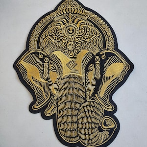 May include: A gold embroidered patch of the Hindu deity Ganesha, an elephant-headed god, on a black background.