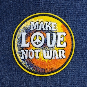 May include: A yellow embroidered patch with a peace sign and the text "Make Love Not War" in white. The background of the patch is a colorful tie-dye pattern.