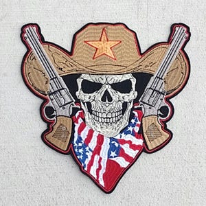 May include: Embroidered patch featuring a skull wearing a cowboy hat with a star on the front, a bandana with an American flag pattern, and two pistols crossed behind the skull.