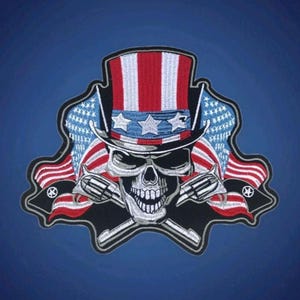 May include: Embroidered patch featuring a skull wearing a patriotic Uncle Sam hat with red, white, and blue stripes and stars. Two crossed revolvers are below the skull, and American flags are on either side.