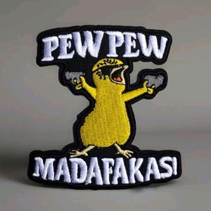 May include: Embroidered patch featuring a yellow cartoon chick with a black eye mask and two guns. The patch has the words "PEW PEW" above the chick and "MADAF**KAS" below, all in white letters on a black background.