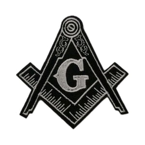 May include: A black and white embroidered patch featuring the Masonic square and compasses symbol. The design includes a central letter G, a square, and a compass, all rendered in white thread against a solid black background with detailed stitching.