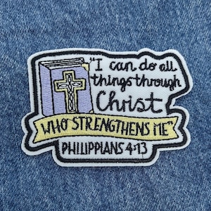 May include: Embroidered patch with the text "I can do all things through Christ who strengthens me Philippians 4:13." The patch features a purple book with a gold cross and a yellow banner.