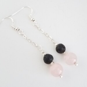 May include: A pair of silver dangle earrings with black lava rock and rose quartz beads.