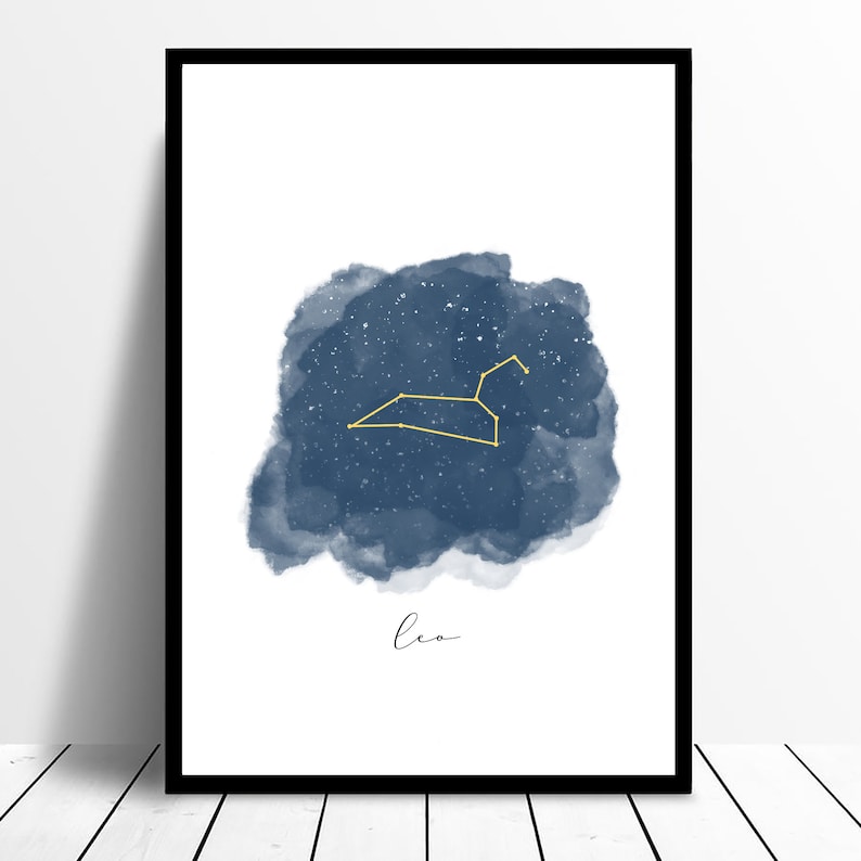 Puede incluir: Una pintura de acuarela de la constelaci&oacute;n de Leo en oro sobre un fondo azul estrellado. La palabra "Leo" est&aacute; escrita en cursiva en la parte inferior de la imagen.