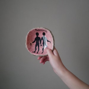Op de afbeelding: Een roze keramische schaal met een bruine rand en een zwart silhouet van het sterrenbeeld Tweelingen. De schaal heeft het woord "Tweelingen" in zwart op de bovenkant.