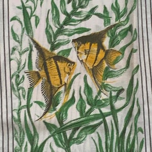 May include: A fabric print depicting two yellow and black angelfish amidst green aquatic plants. The background is white with vertical black stripes and decorative corner elements. The fish have detailed fin and scale patterns.