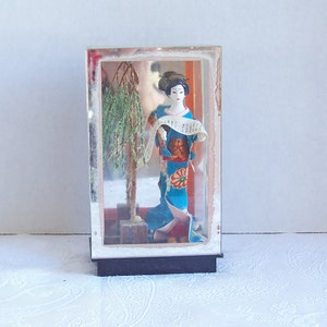 A Very Detailed and Beautiful Geisha Holding a Scroll in a Plastic Display Case, Made in Japan
