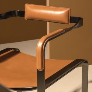 Puede incluir: Una silla de cuero marr&oacute;n con estructura de metal negro. La silla tiene un reposacabezas y reposabrazos acolchados.