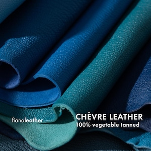 May include: Close-up of several pieces of blue and green leather. The leather is folded and textured. The text "CH&Egrave;VRE LEATHER 100% vegetable tanned" is visible at the bottom of the image.