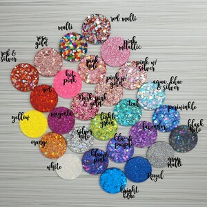 Op de afbeelding: Assortiment van glitterkleuren in kleine ronde containers. De kleuren omvatten rood, roze, blauw, groen, geel, oranje, wit, zwart, zilver, goud, teal, lavendel, magenta, periwinkle, aqua, en meer.