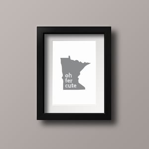 May include: A black framed print featuring a grey outline of the state of Minnesota. The text "oh fer cute" is written in white within the outline.