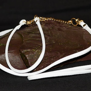 Op de afbeelding: Hondenhalsband en -riem van wit leer met een gouden kettingdetail.