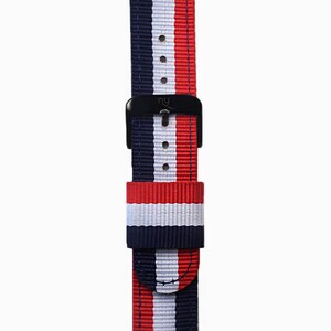 May include: A red, white, and blue striped watch strap with a black buckle. The strap is made of nylon and has a stitched edge.