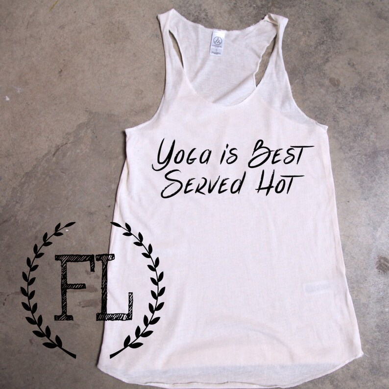 May include: White tank top with black text that reads "Yoga is Best Served Hot".