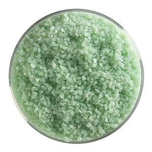 May include: A close-up view of a bowl filled with light green, small, irregular shaped, polished stones.