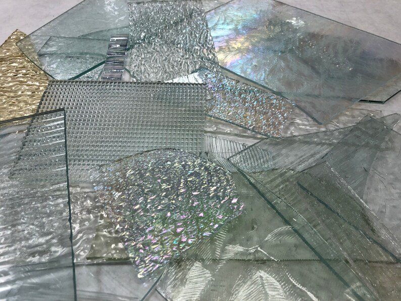 May include: Assortment of clear glass sheets with various textures, including a grid pattern, wavy, and iridescent.