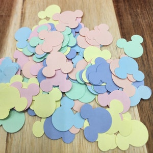 May include: A pile of pastel-coloured paper confetti shaped like Mickey Mouse heads. The confetti is in shades of yellow, blue, pink, and green.