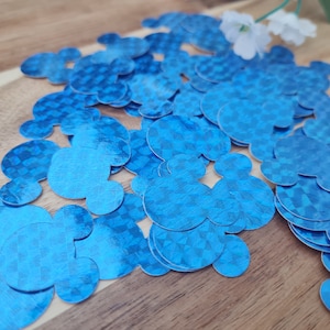 May include: A pile of blue, metallic, mouse-shaped confetti. The confetti has a checkered pattern.