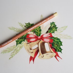 May include: A close-up of a brown colored pencil with the text "Permanent Color 3611 Light Oak" on the side. The pencil is lying on a white surface with a drawing of a Christmas wreath with holly leaves, pine needles, and two gold bells with a red bow.