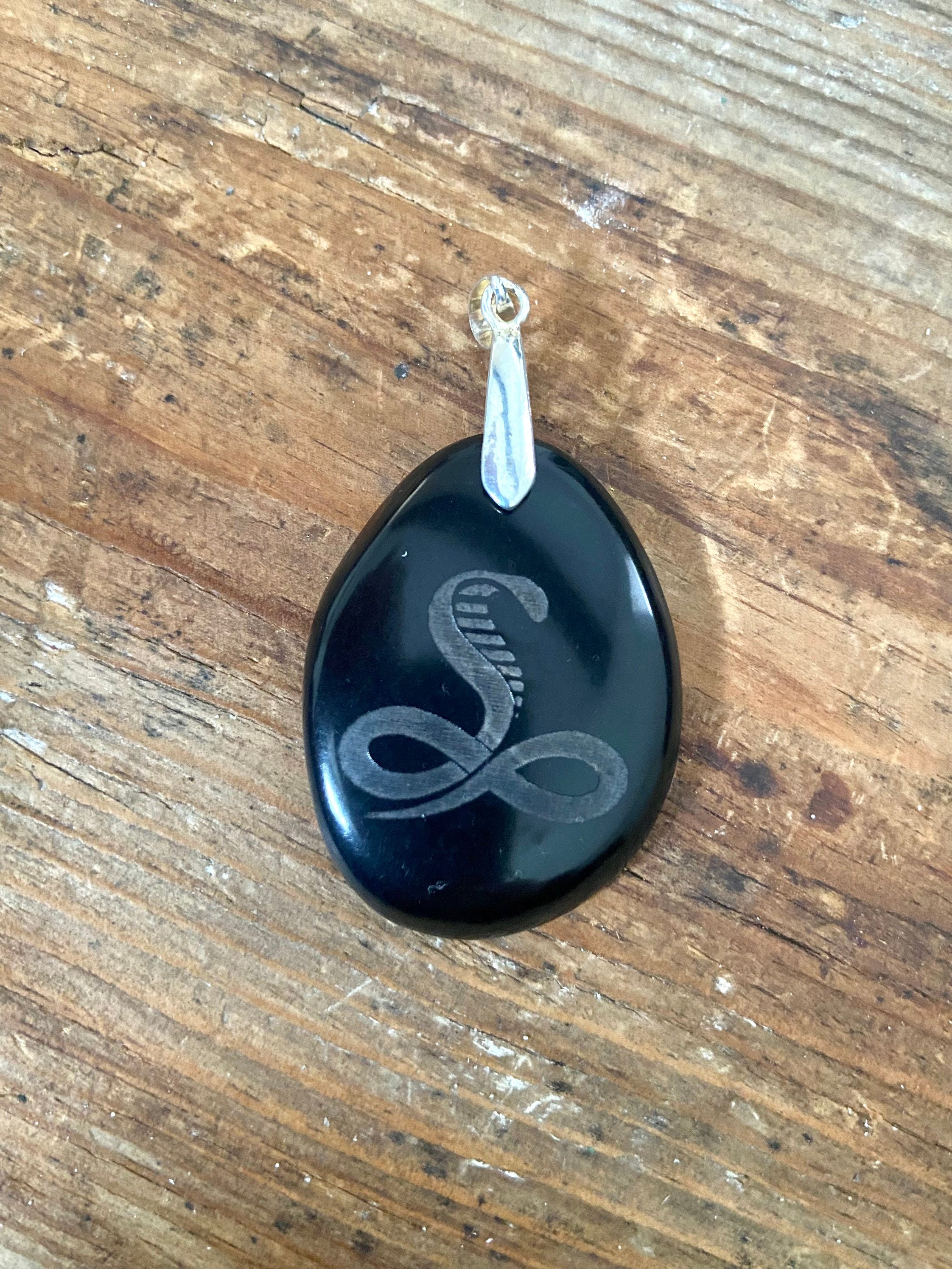 Smooth black snake Eco Tagua nut pendant on silver bail.