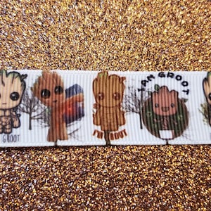 May include: White ribbon with a repeating pattern of a cartoon character with the text "I am Groot" and "I'm Groot".