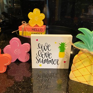 Bandeja escalonada de verano: piña de madera, flores y letreros