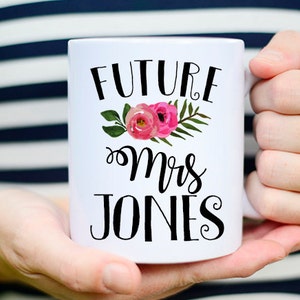 May include: White ceramic mug with a black floral design and the text "FUTURE Mrs JONES".