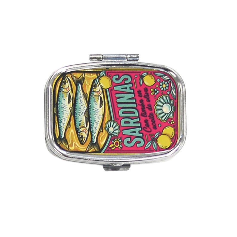 May include: A silver-toned pill box with a hinged lid. The box features a pink background with a sardine can design. The design includes illustrations of sardines, lemons, and the word "SARDINAS".