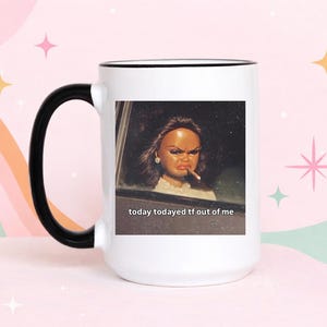 May include: White ceramic mug with a black handle and rim. The mug features a vintage-style image of a doll in a car, smoking a cigarette, with the text "today todayed tf out of me".