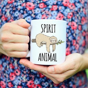May include: White ceramic mug with a sloth illustration and the text "SPIRIT ANIMAL" printed on it.