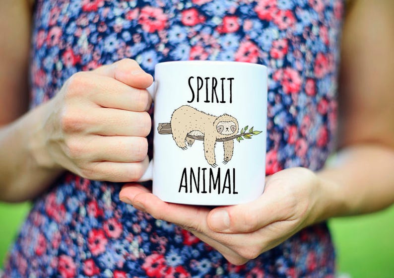 May include: White ceramic mug with a sloth illustration and the text "SPIRIT ANIMAL" printed on it.